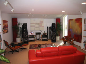 hifi room with red couch and red tupetraps in the front corners